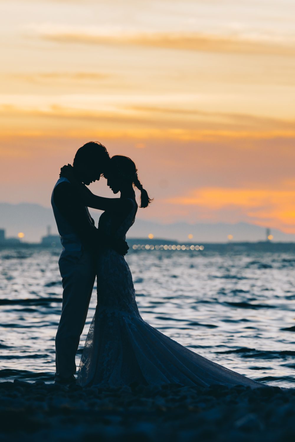 夕景が美しい浜辺で誓い合う新郎新婦様のシルエットショット