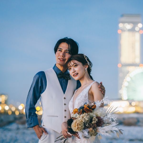 体を寄せ合って海を眺める新郎新婦様の結婚写真