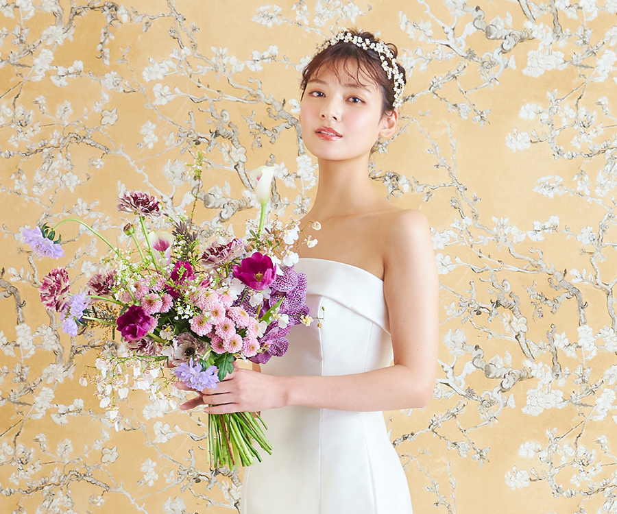           花束を抱えてこちらを見つめる新婦様のウェディングフォト          