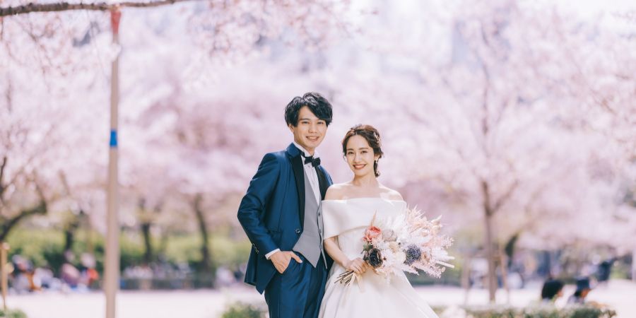 ダイナミックに咲き誇る桜に囲まれた新郎新婦様のロケーションフォト
