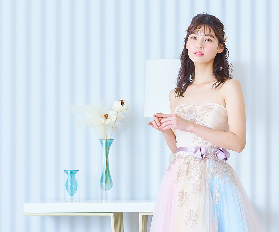           爽やかなブルーの背景セットと淡い色合いのカラードレスがマッチした新婦様のソロショット          