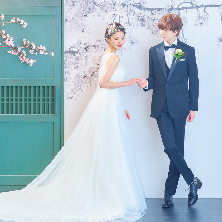           桜の木の下で新婦様の手を取る新郎様のウェディングフォト          