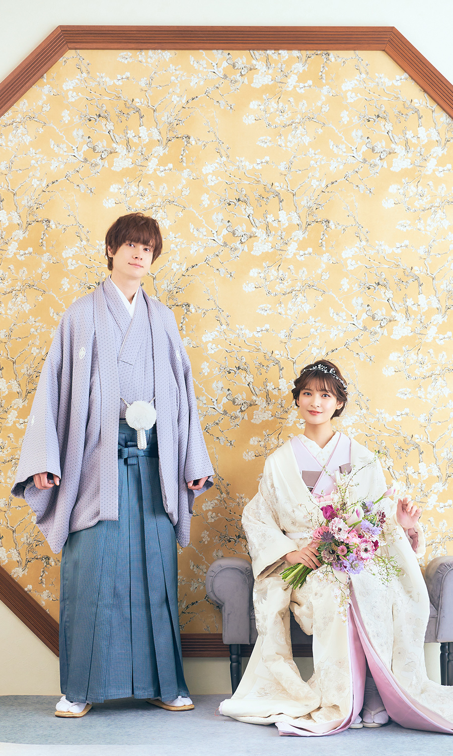           ブーケを持って椅子に座る新婦様と隣で微笑む新郎様の和装結婚写真          