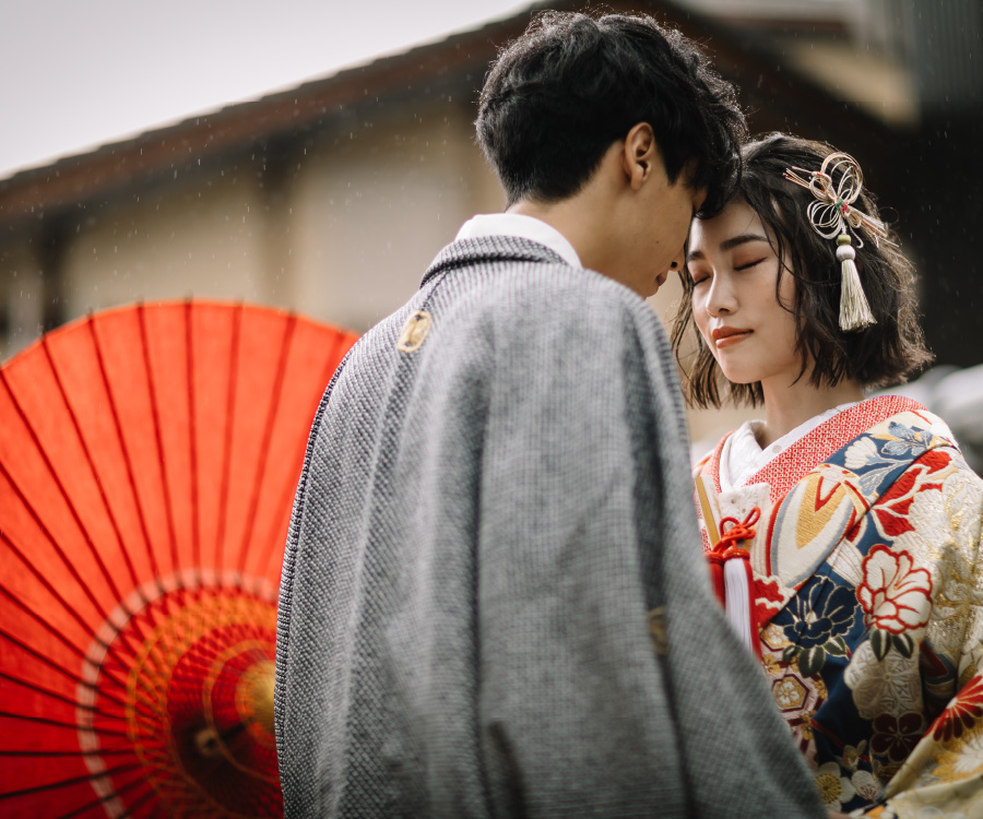 和傘を横にさしながらおでこをくっつける新郎新婦様の結婚写真