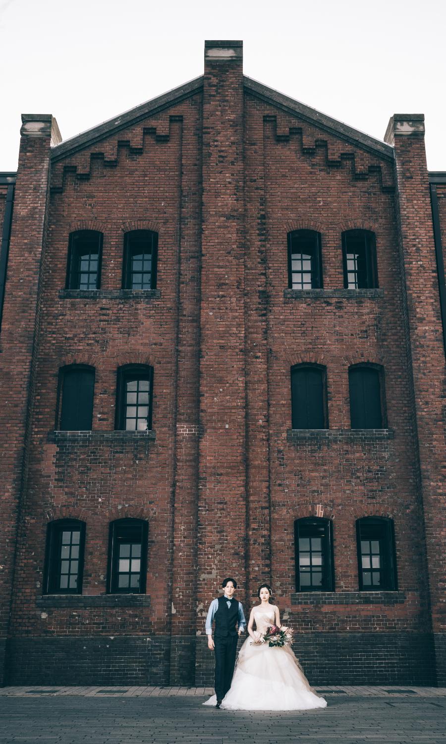 赤レンガ倉庫の前に佇む新郎新婦様のウェディングフォト