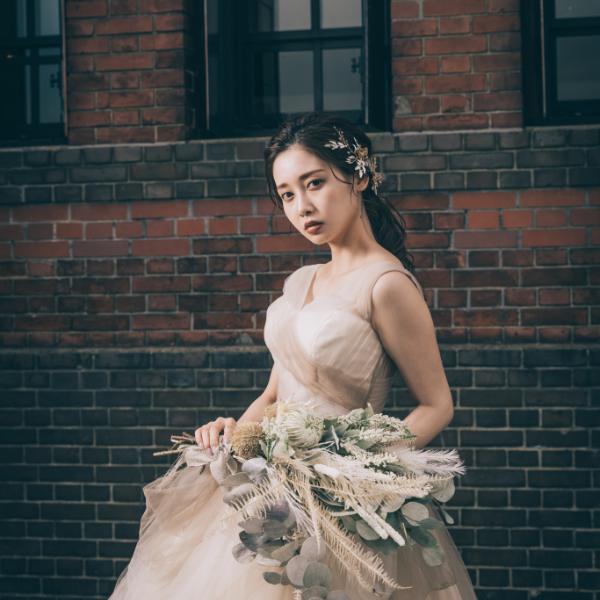 花束を持ちながら凛とした表情をする新婦様のウェディングフォト