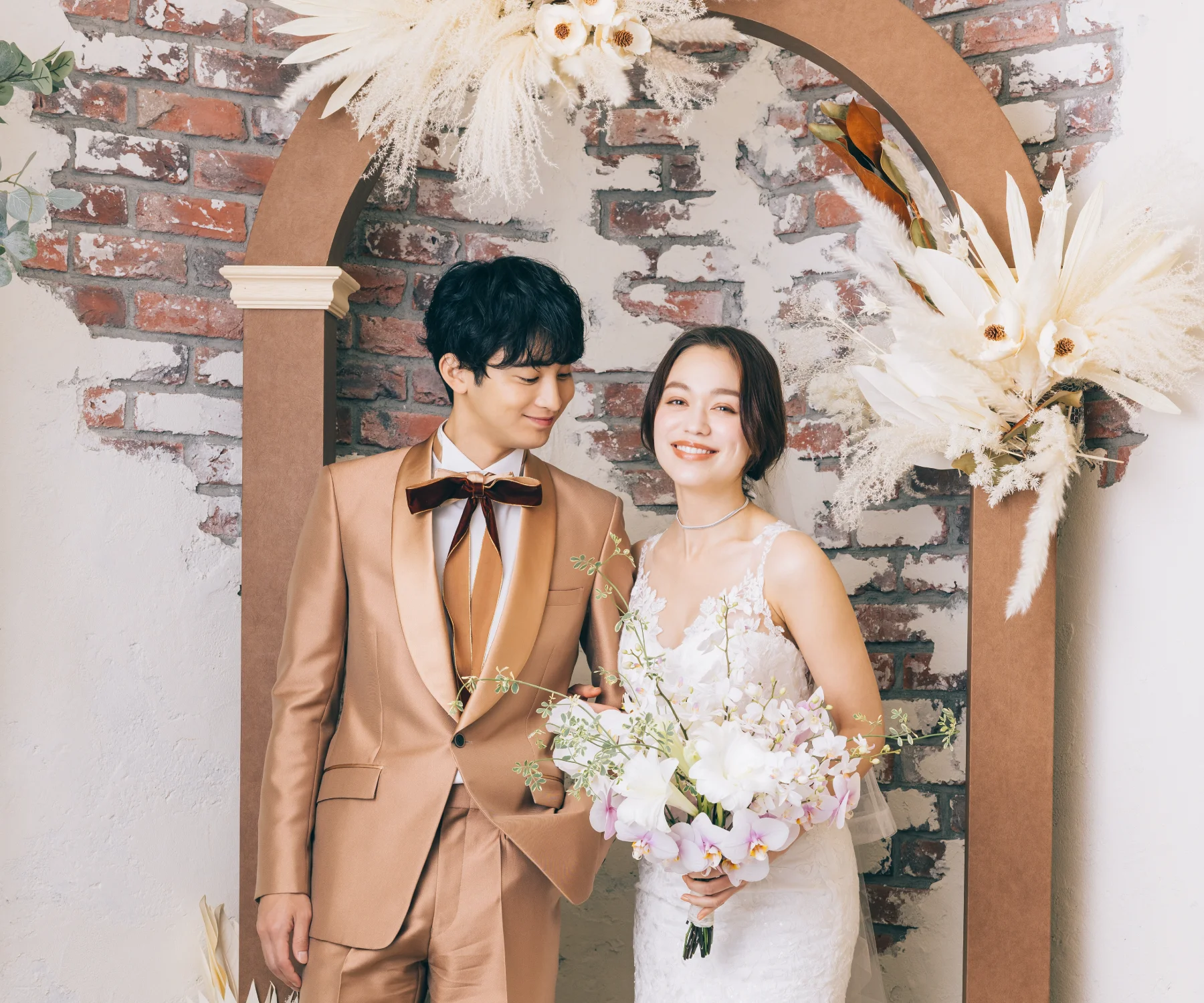 漆喰の壁から顔をのぞかせる赤レンガとレトロチックなドライフラワーのスタジオ