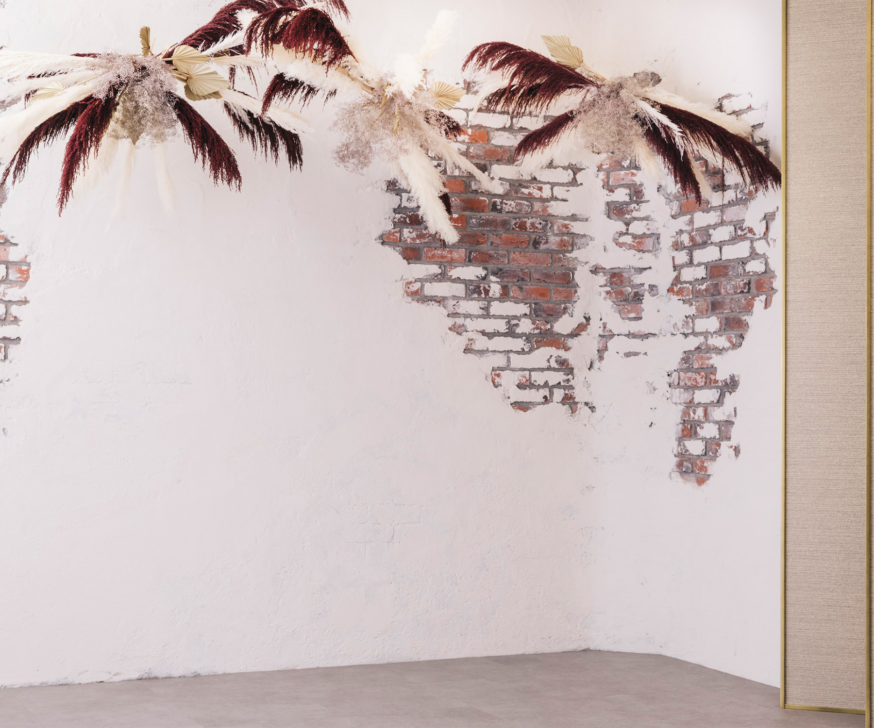 漆喰の壁から顔をのぞかせる赤レンガとレトロチックなドライフラワーのスタジオ