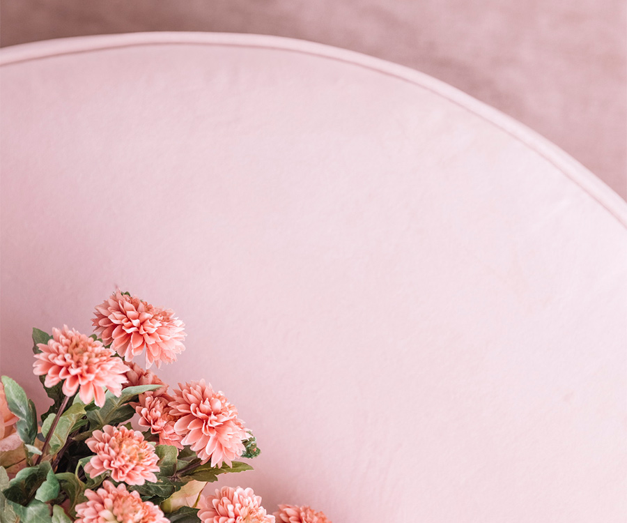 ピンクのソファに据えられたバラの写真