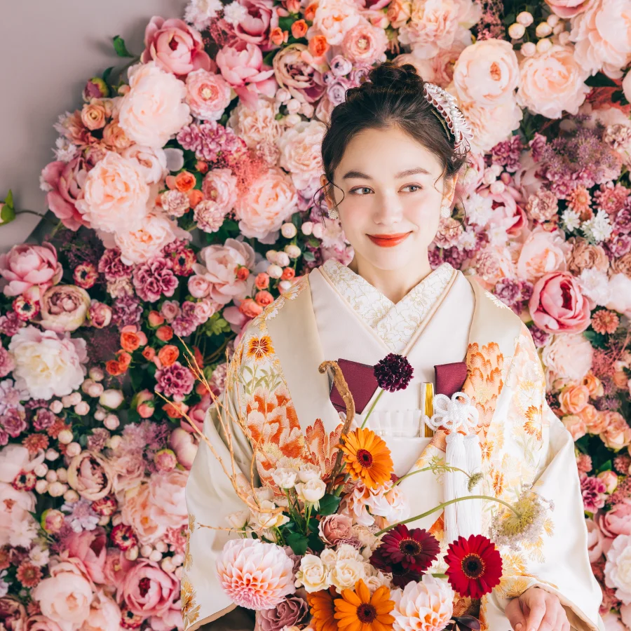 淡いピンクのソファに濃いピンクのバラが置いてある写真