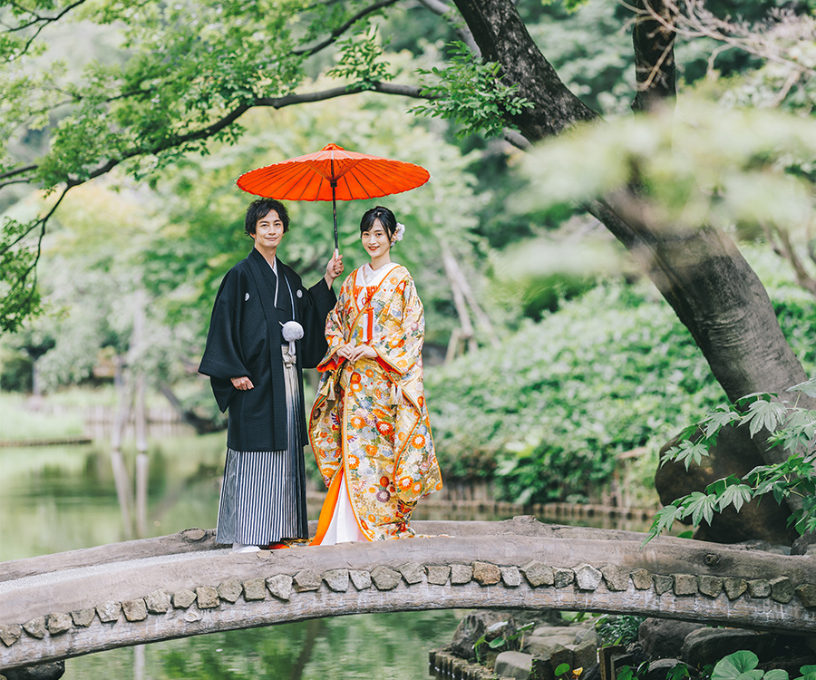 肥後細川庭園の石橋で和傘をさす新郎様と新婦様の結婚写真