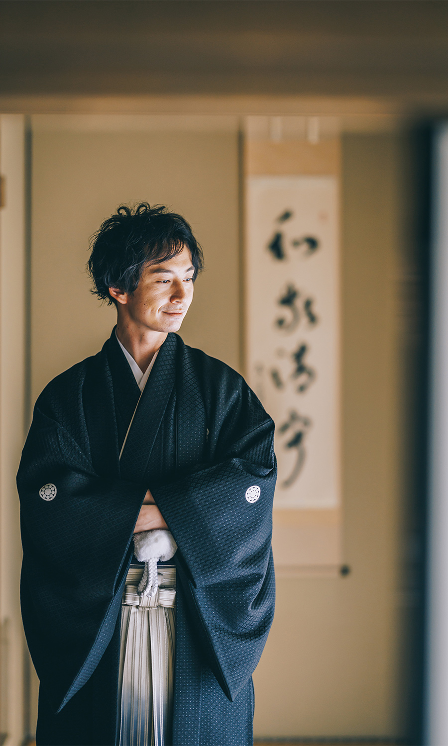掛け軸を背景に袖に腕をしまう新郎様の和装前撮り