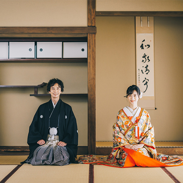 和室で正座をしながら微笑む新郎新婦様の和装前撮り