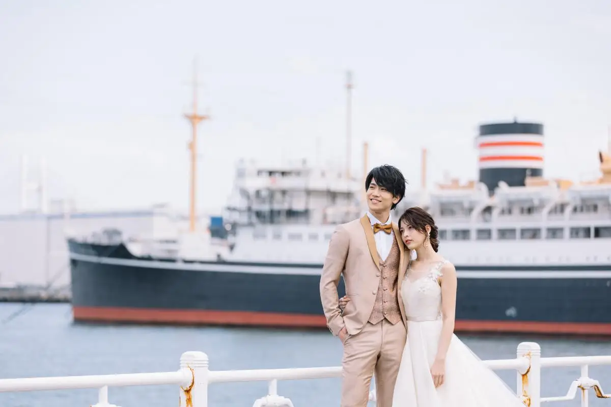 山下公園でフェリーを背景に微笑む新郎新婦のウェディングフォト