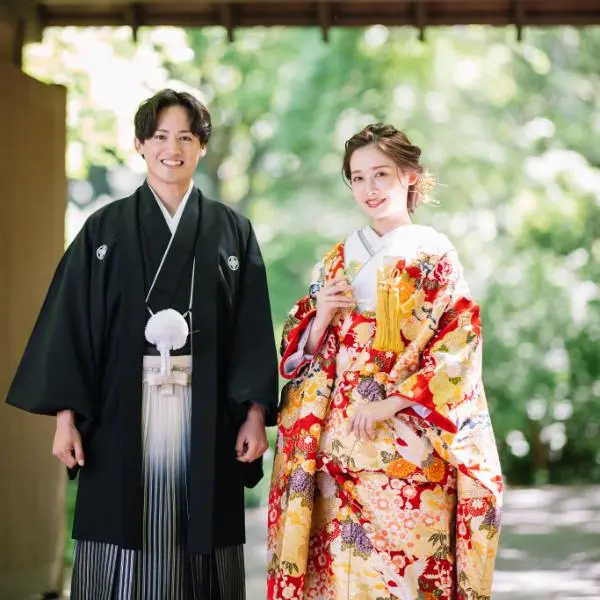 門の前で朗らかな笑顔をしている新郎新婦様の結婚写真