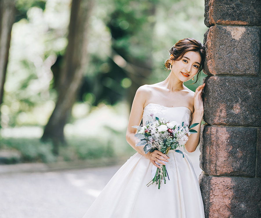 洋館の壁に寄り掛かる新婦様のウェディングフォト