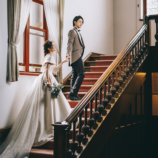 階段で新婦様の手をとる新郎様の結婚写真