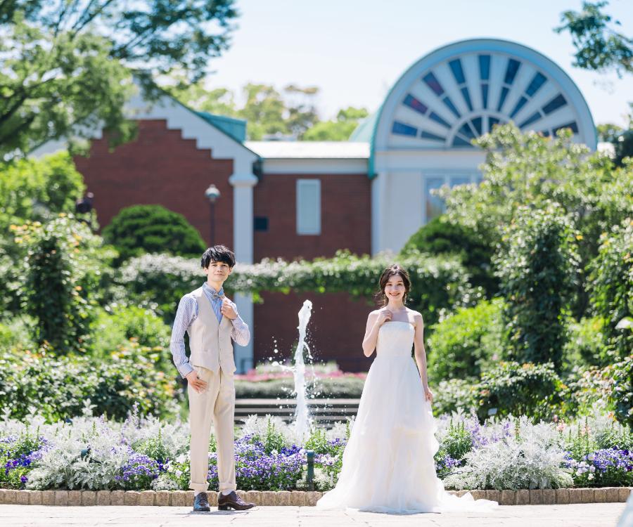 噴水の前で並ぶ新郎様と新婦様のウェディングフォト