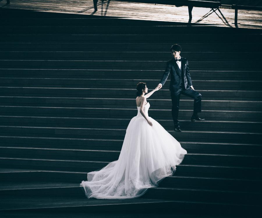 階段で新婦様の手をとる新郎様のウェディングフォト