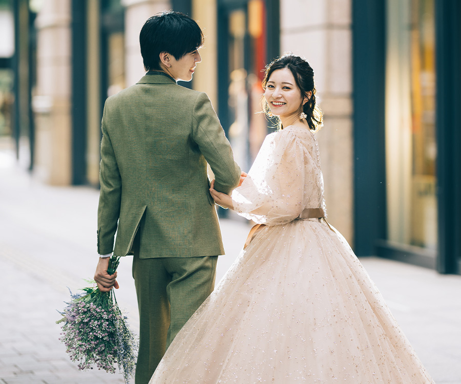 和田倉門で花を持った新婦様と並ぶ新郎様のロケーションフォト