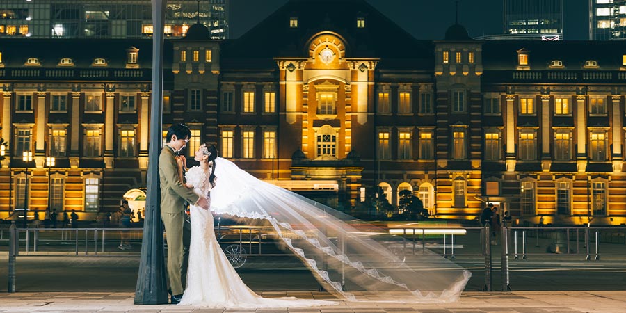 東京駅の夜景をバックに遠くを見つめる新郎新婦様の結婚写真