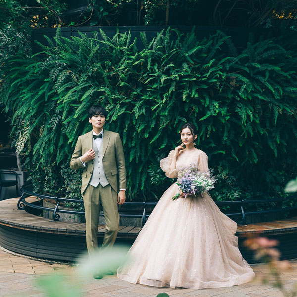 ライトアップされた東京駅の前で遠くを見つめる新郎新婦様のウェディングフォト