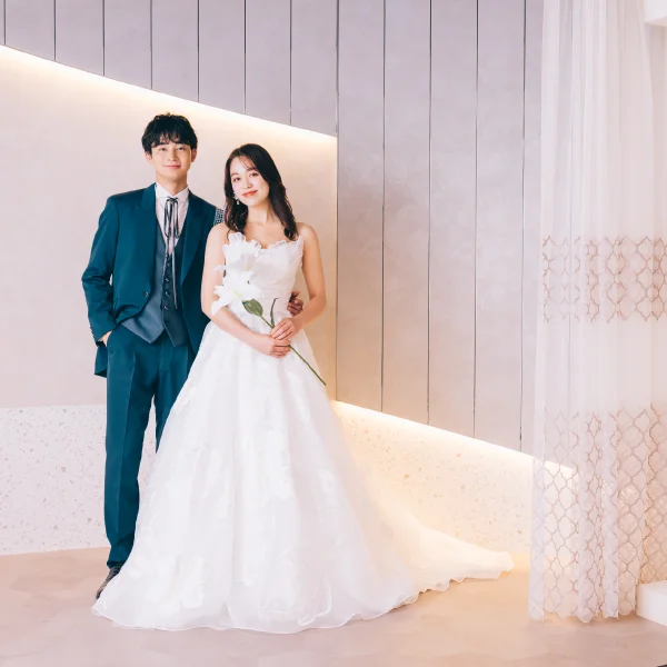 バラをバックにソファに座る新婦様のソロショット                    