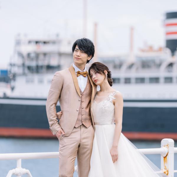 フェリーを背景に遠くを見つめる新郎新婦様のウェディングフォト