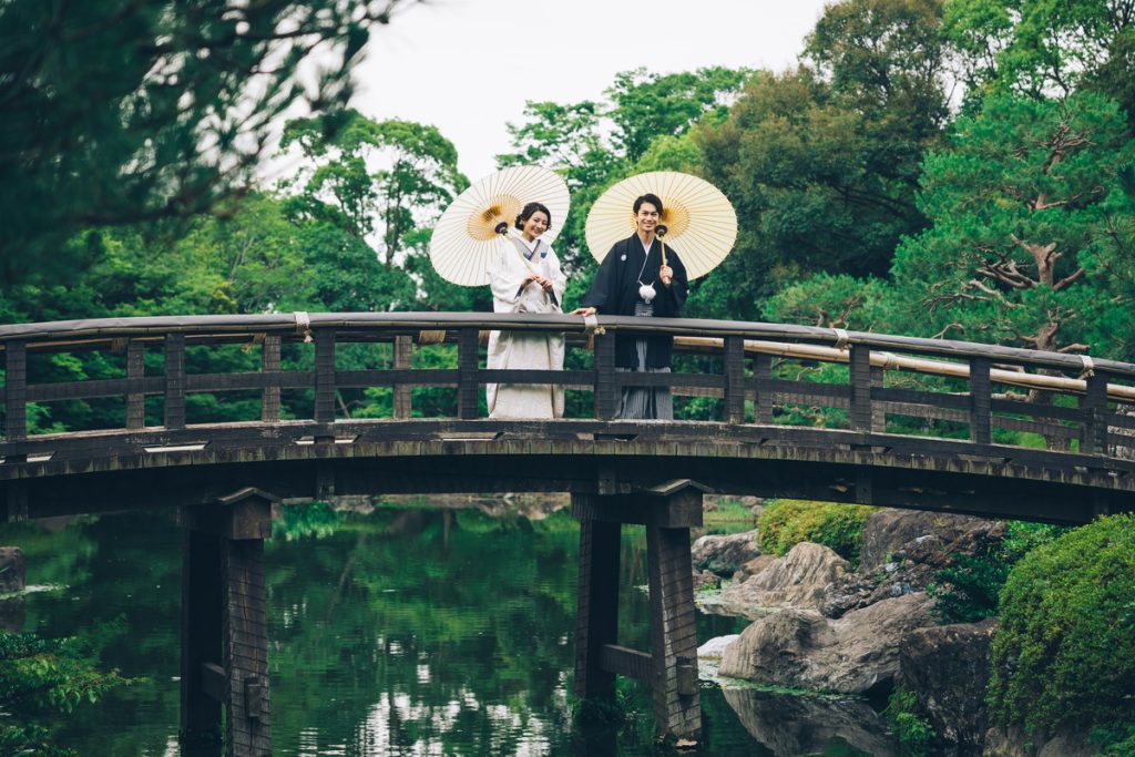和傘をさしながら橋からの景色を楽しむ新郎新婦様