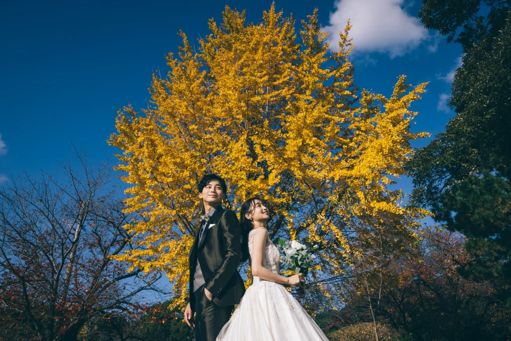 冬の青空と紅葉をバックに新郎新婦様のロケーションフォト