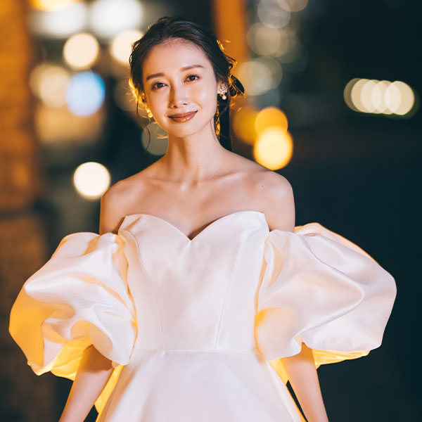 花束を持ちながら凛とした表情をする新婦様のウェディングフォト