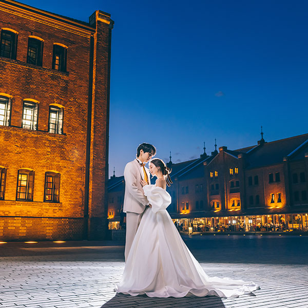 芝生の上に座って微笑む新郎新婦様のウェディングフォト