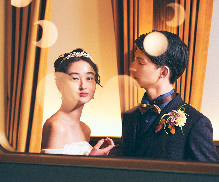      車窓越しにこちらを見つめる新婦様と新郎様のアップショット               