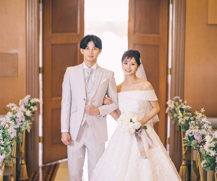 バージンロードで新郎様と腕を組む新婦様のウェディングフォト