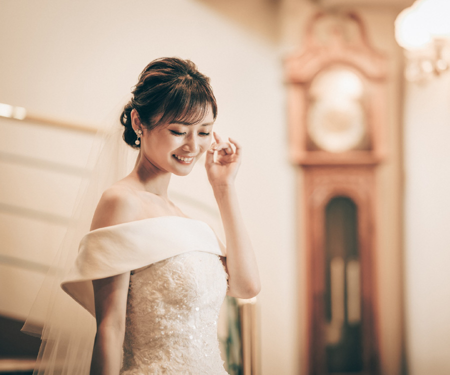 大きな振り子時計をバックに微笑む新婦様のソロショット