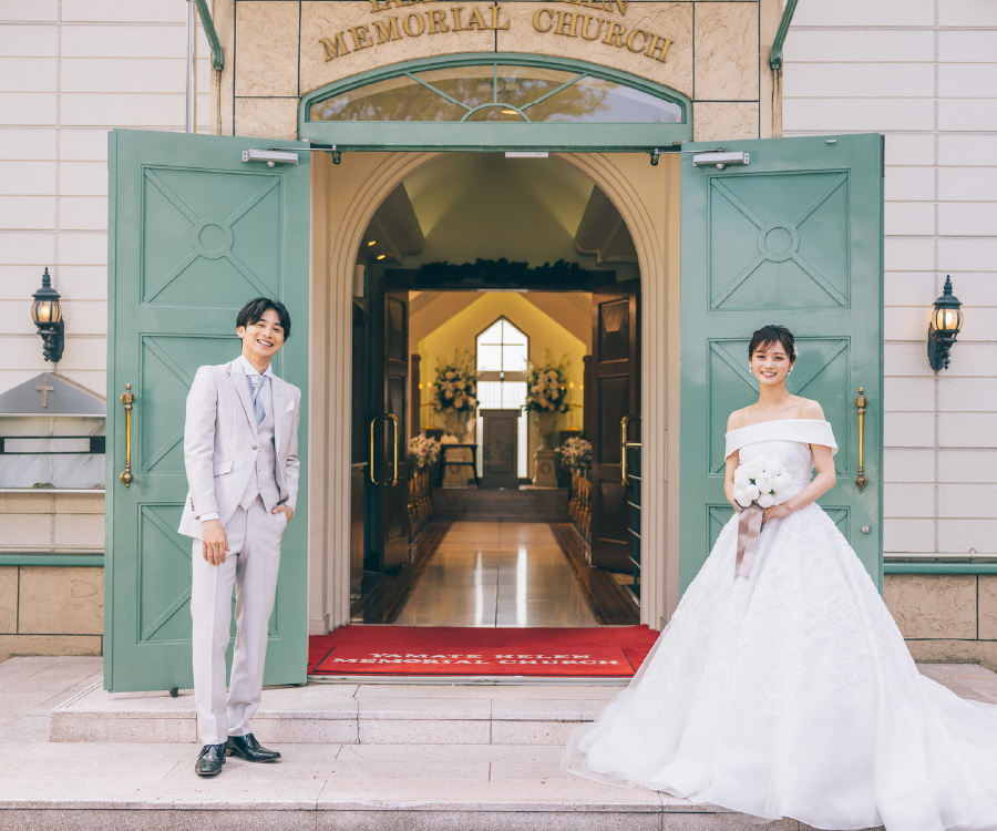 教会の扉の前で微笑む新郎新婦様の結婚写真