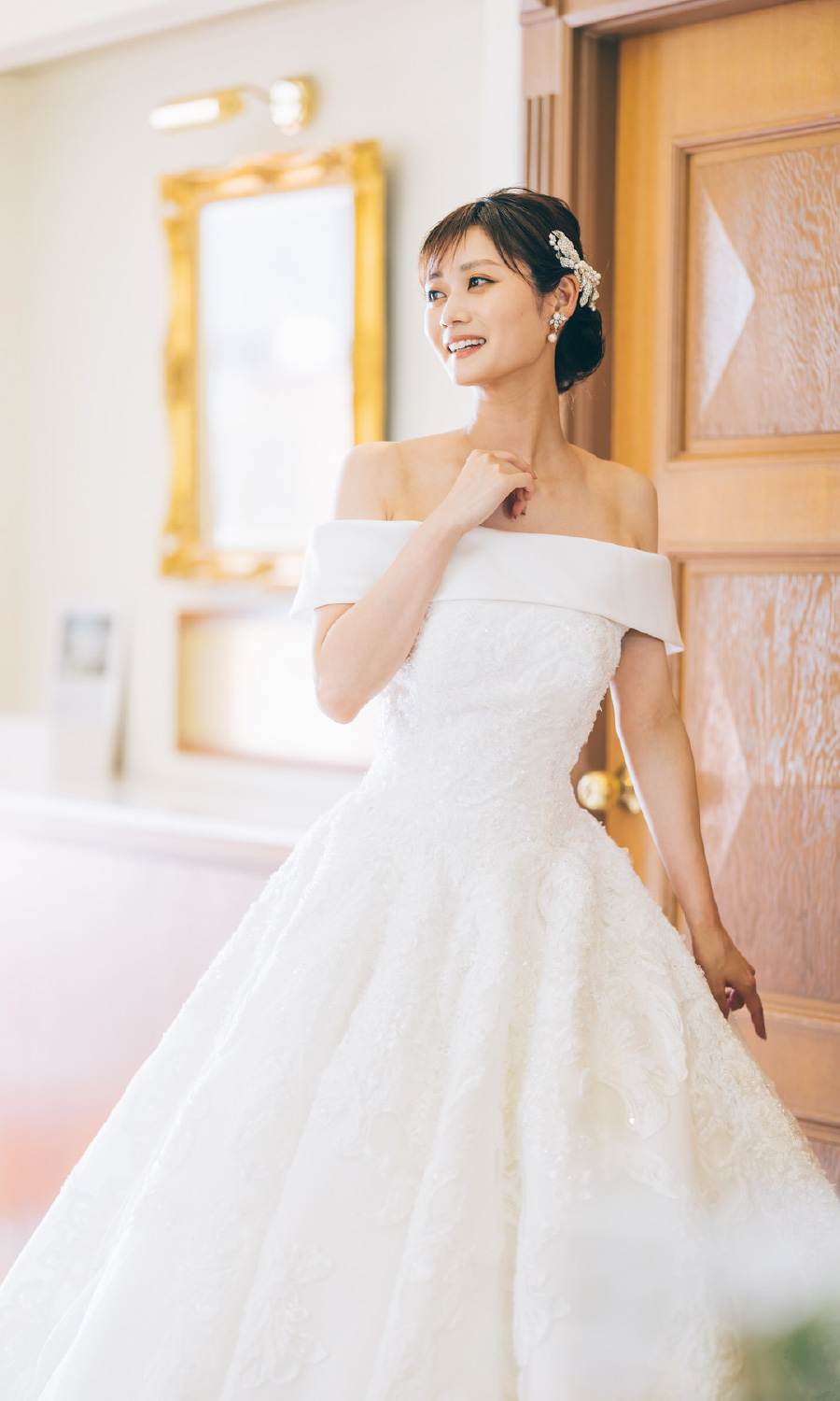 ウェディングドレスを着て笑顔で遠くを見つめる新婦様のソロショット