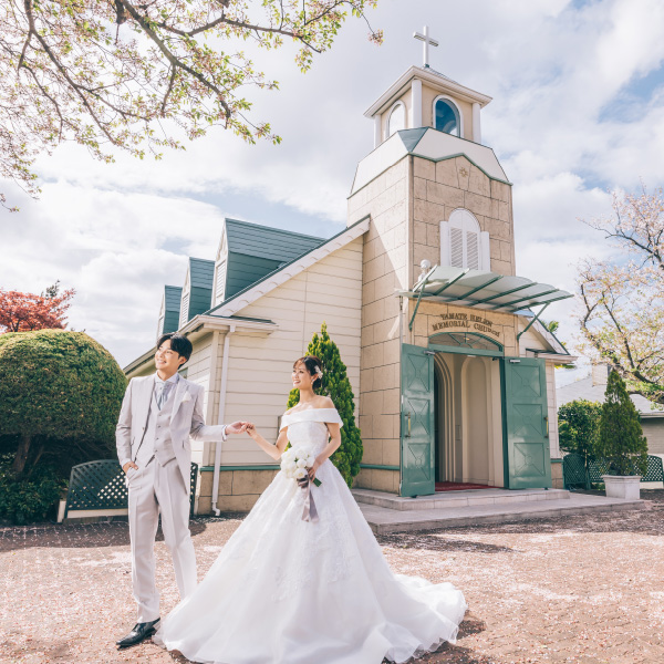 山手ヘレン記念教会の前で新婦様の手を取る新郎様のロケーションフォト