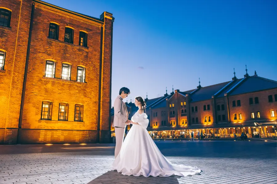 横浜赤レンガ倉庫の前で背中をくっつけあう新郎新婦様の結婚写真