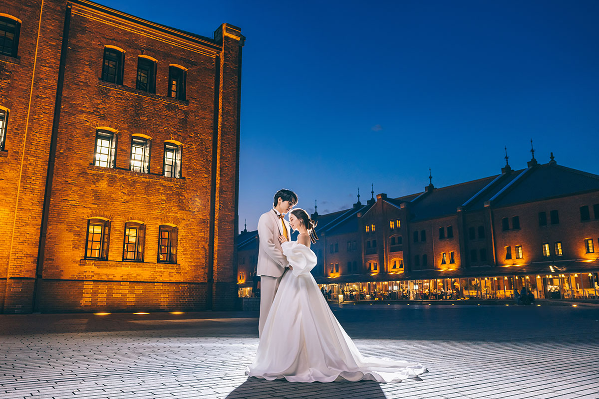 横浜赤レンガ倉庫の前で背中をくっつけあう新郎新婦様の結婚写真