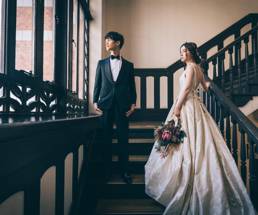 二人で大きな窓から景色を眺める新郎新婦様のウェディングフォト