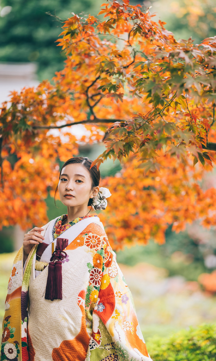 ダイナミックな紅葉の下でアンニュイな表情をする新婦様