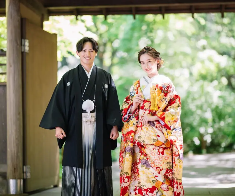 門の前で明るい笑顔をした新郎新婦様の結婚写真