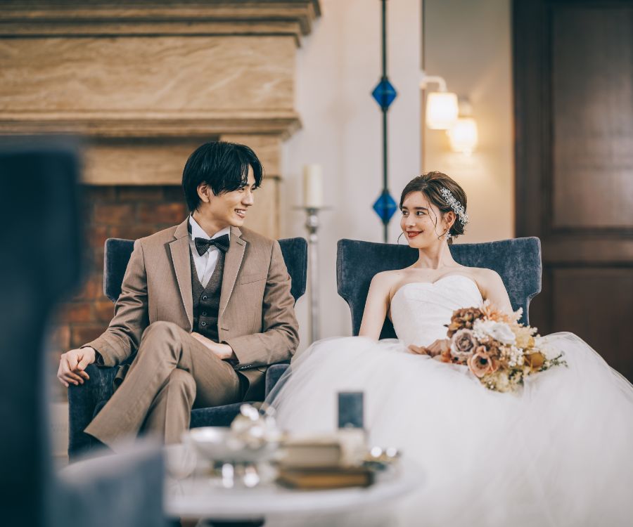ソファに座りながら談笑する新郎新婦様の結婚写真
