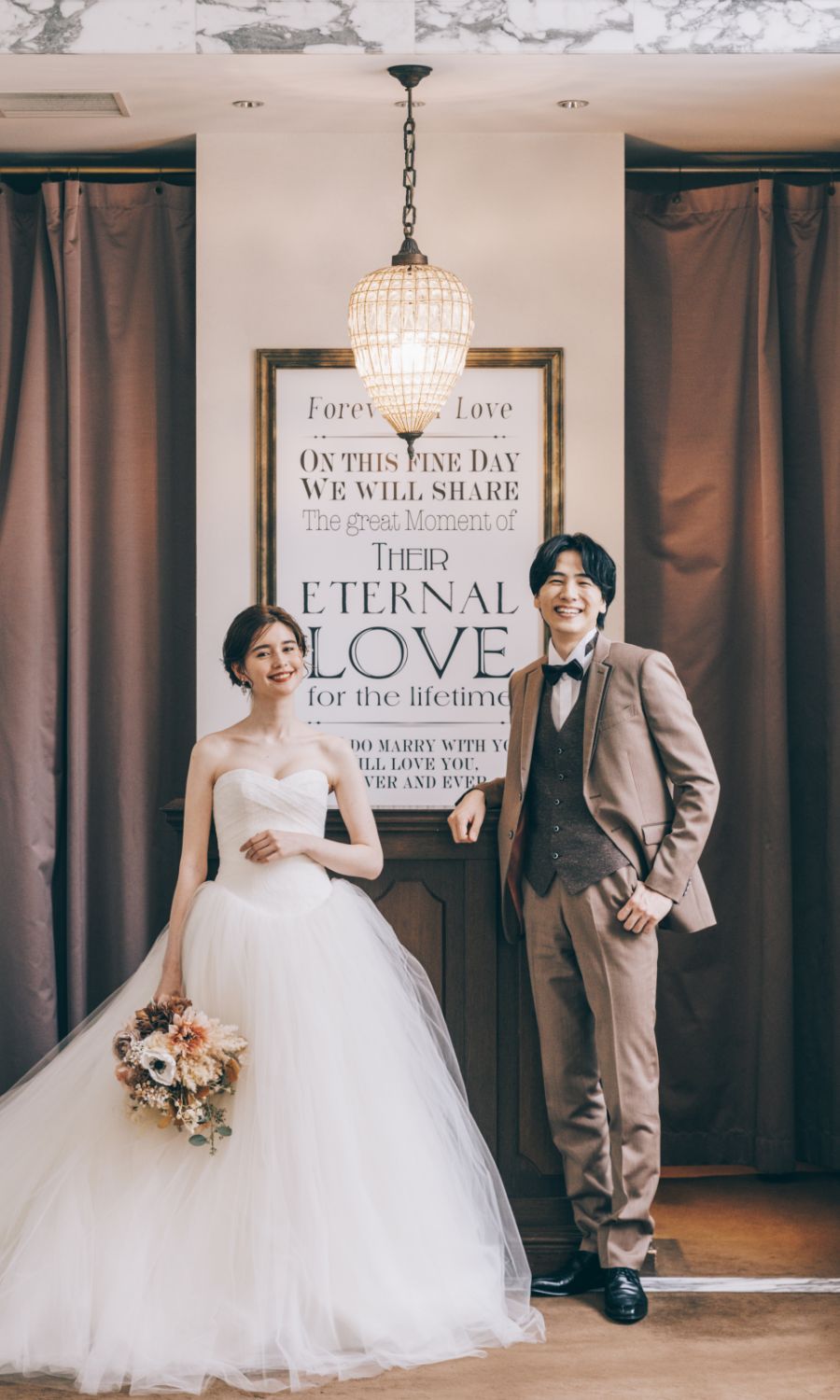 ブーケを片手に微笑む新婦様と新郎様のウェディングフォト