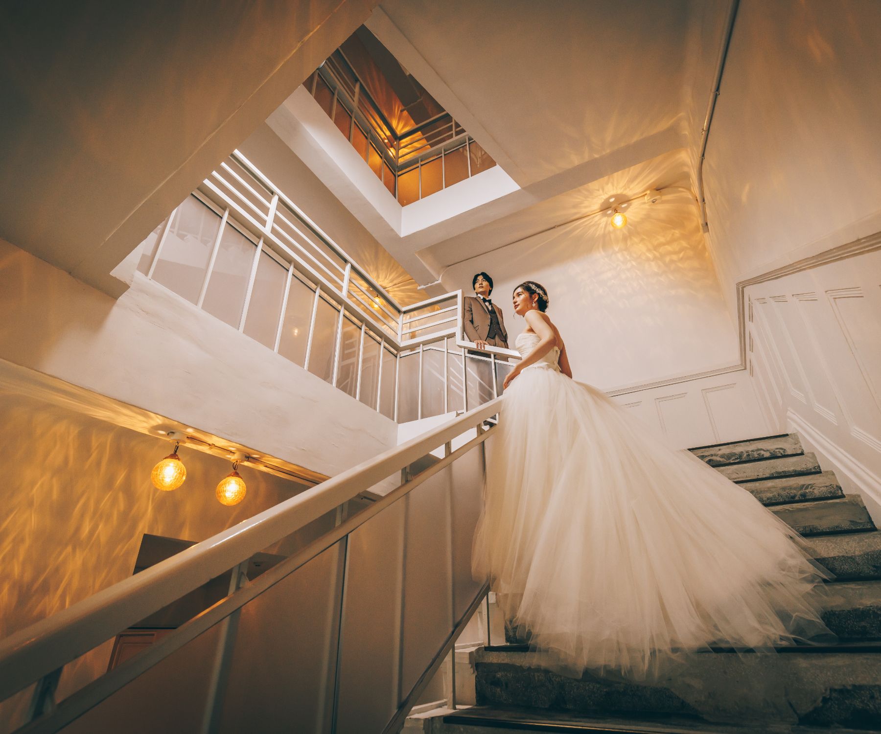 アンニュイな表情で階段に佇む新郎新婦様のウェディングフォト