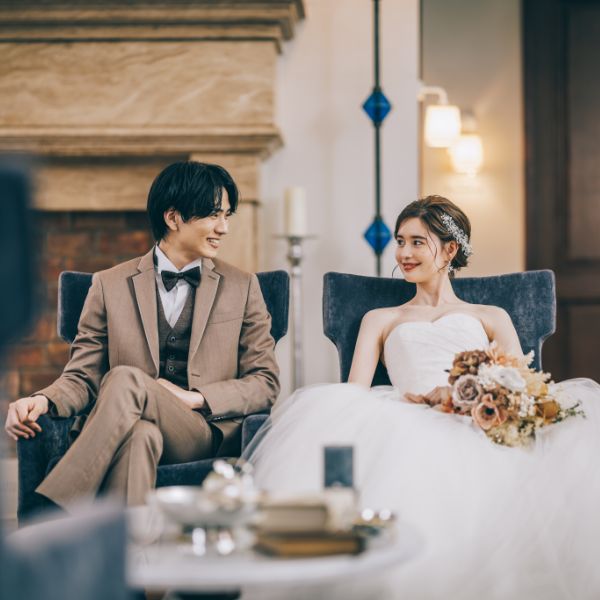 ソファに並んで座る新郎新婦様の結婚写真