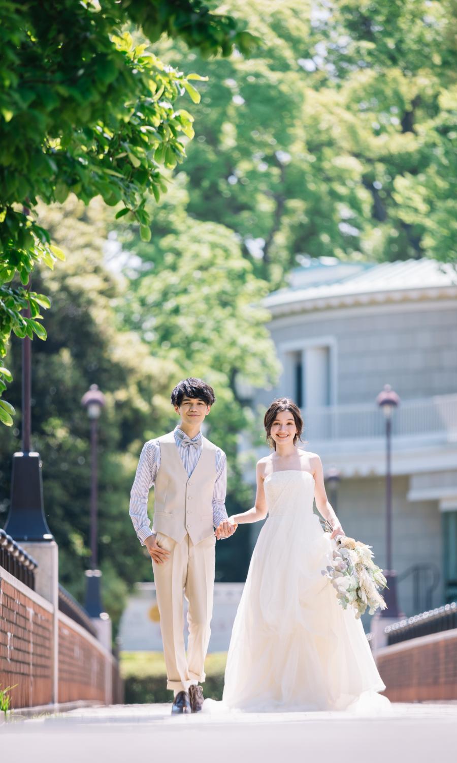 橋の上で新婦様の手をとる新郎様のウェディングフォト