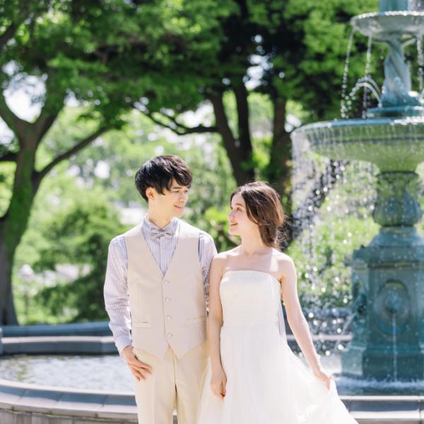 噴水の前で談笑する新郎新婦様のウェディングフォト
