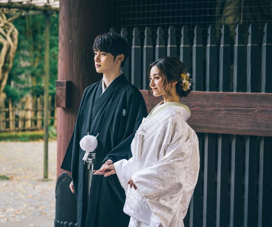 門の下で景色を眺める新郎新婦様の結婚写真